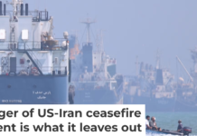 A small motorboat passes anchored vessels in the Strait of Hormuz off Bandar Abbas, Iran, on June 11, 2026. Amirhosein Khorgooi/ISNA via AP